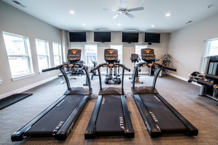 three treadmills side-by-side within a workout room